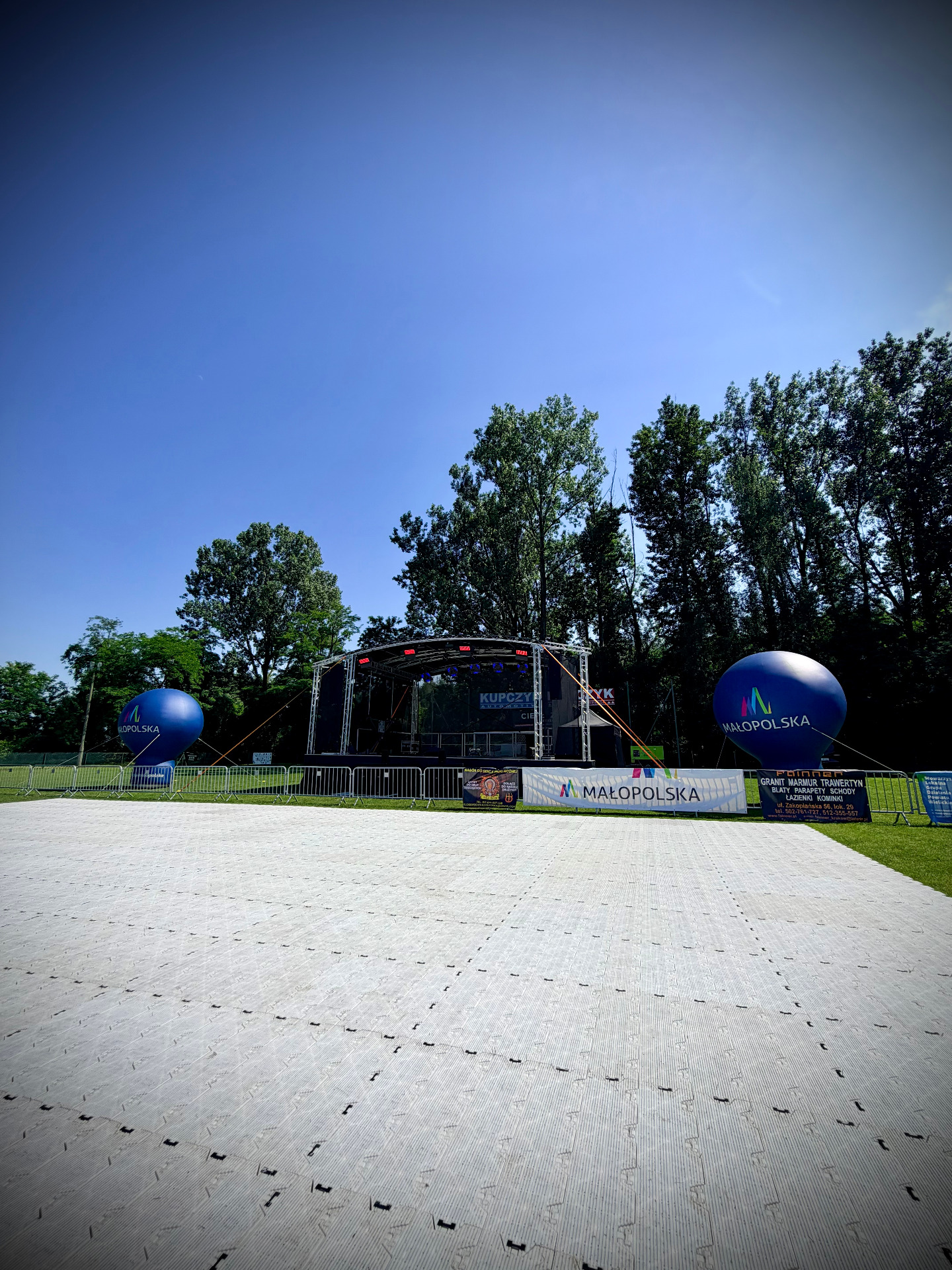 Widok na scenę koncertową podczas III Dni Kokotowa 2026 wraz z profesjonalnym nagłośnieniem, oświetleniem oraz podłogą Event Floor Arena ułożoną na stadionie. Event Serwis zapewnił kompleksową realizację techniczną wydarzenia, zabezpieczenie stref barierkami ochronnymi oraz obsługę koncertów i części artystycznej.